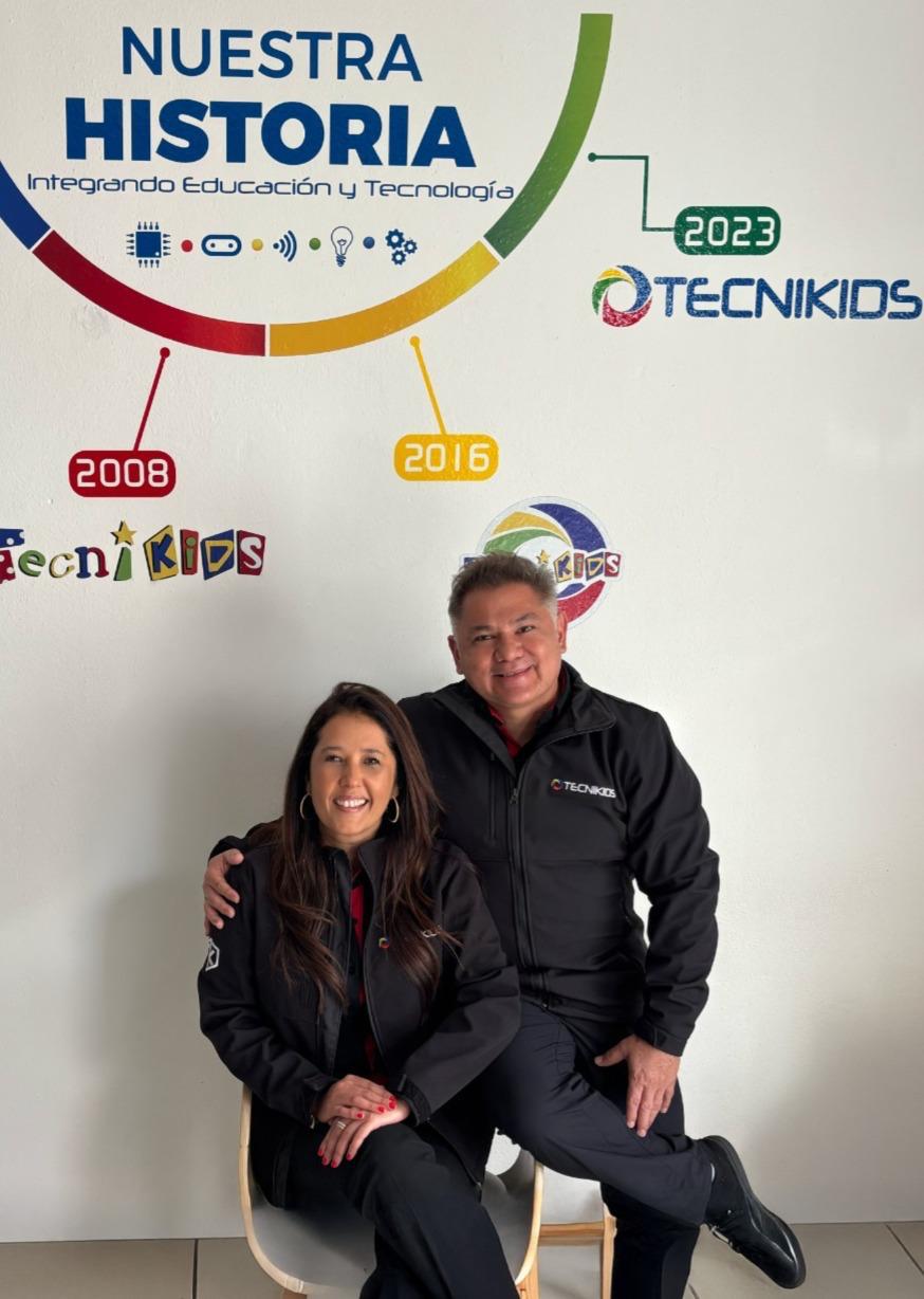 Giovanni Montes y Claudia Zuñiga de Montes frente al mural de la historia de Tecnikids